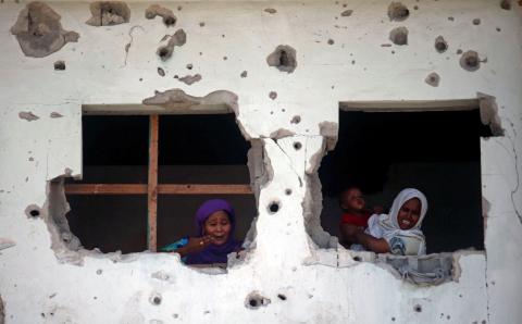 Somali women react from an adjacent building as they look at the scene of an explosion at the entrance of a cafe near the compounds housing government ministries in the Somali capital Mogadishu, April 5, 2017. PHOTO BY REUTERS/Feisal Omar