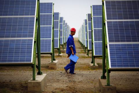 A worker inspects solar panels at a solar farm in Dunhuang, 950km (590 miles) northwest of Lanzhou, Gansu Province, September 16, 2013. PHOTO BY REUTERS/Carlos Barria