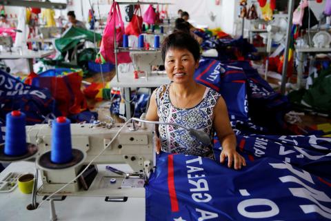 A worker poses for pictures as she makes flags for U.S. President Donald Trump's "Keep America Great!" 2020 re-election campaign at Jiahao flag factory in Fuyang, Anhui province, China, July 24, 2018. PHOTO BY REUTERS/Aly Song