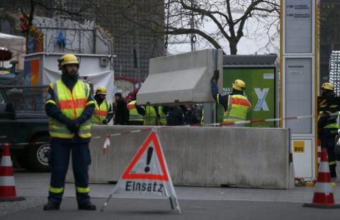 Workers place concrete barriers outside the Christmas market at Breitscheid square in Berlin, Germany, December 22, 2016, following an attack by a truck which ploughed through a crowd at the market on Monday night. PHOTO BY REUTERS/Hannibal Hanschke