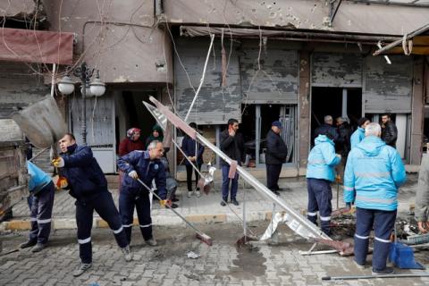 Municipality workers clean up a street in front of a building which was hit by rockets fired from Syria, in the border town of Reyhanli in Hatay province, Turkey, January 22, 2018. PHOTO BY REUTERS/Umit Bektas