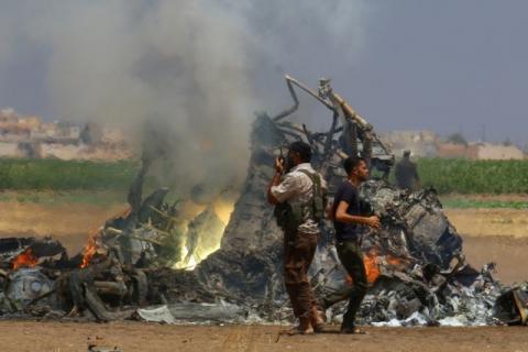 Men inspect the wreckage of a Russian helicopter that had been shot down in the north of Syria's rebel-held Idlib province, Syria, August 1, 2016. PHOTO BY REUTERS/Ammar Abdullah