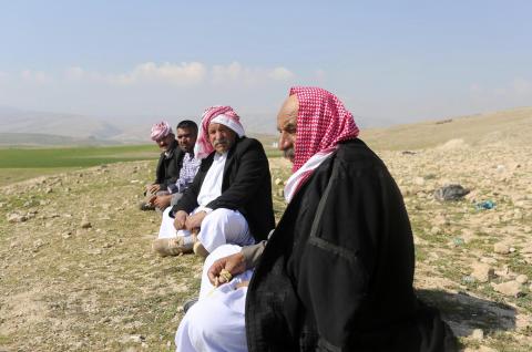 Yazidi refugees talk on a hill overlooking their refugee camp on the outskirts of Duhok, February 26, 2015. PHOTO BY REUTERS/Asmaa Waguih