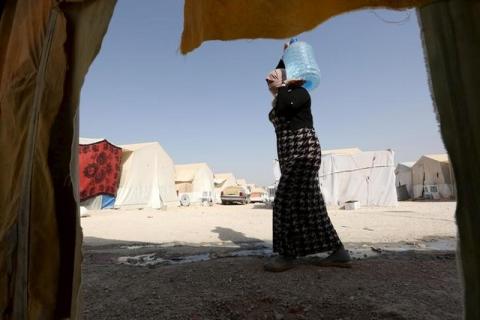 A 27-year-old Yazidi woman, who escaped from captivity by Islamic State (IS) militants, carries water at Sharya refugee camp on the outskirts of Duhok province, July 4, 2015. PHOTO BY REUTERS/Ari Jala