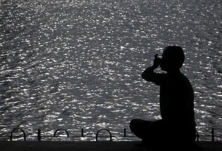 A man practices yoga on the promenade next to a lake in Agartala, India early June 16, 2015. PHOTO BY REUTERS/Jayanta Dey