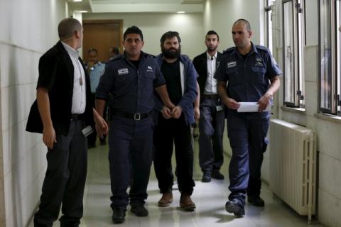 Yosef Haim Ben-David (C), who was convicted of murdering a Palestinian teenager in Jerusalem, is led out of the courtroom by Israeli prison guards at Jerusalem's District Court, April 19, 2016. PHOTO BY REUTERS/Ammar Awad
