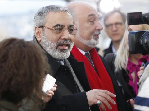 Syrian Information Minister Omran Zoabi (L) speaks to a journalist during his arrival for a meeting with U.N.-Arab League envoy for Syria Lakhdar Brahimi (not seen) at a U.N. office in Geneva