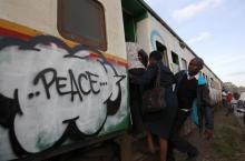 Commuters board a train painted with murals in Kenya's capital Nairobi, February 25, 2013. PHOTO BY REUTERS/Thomas Mukoya