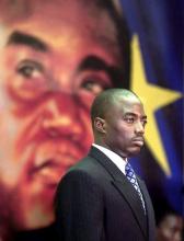 Joseph Kabila, standing in front of a portrait of his late father Laurent, waits to be sworn in as president of the Democratic Republic of Congo during a ceremony in Kinshasa, January 26, 2001. PHOTO BY REUTERS/Juda Ngwenya