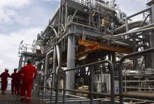 Oil workers walk through pipe installations on a tanker at Bonga off-shore oil field outside Lagos. PHOTO BY REUTERS/Akintunde Akinleye