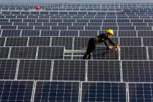 A man works on solar panels at a solar power plant of China Huaneng Group in Huaiyin, Jiangsu province, China, June 13, 2018. PHOTO BY REUTERS/Stringer