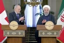 Swiss President Johann Schneider-Ammann (L) and Iranian President Hassan Rouhani clap after a news conference in Tehran, February 27, 2016. PHOTO BY REUTERS/Raheb Homavandi