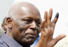 Angola's President Jose Eduardo dos Santos shows off his inked finger to photographers after casting his vote during national elections