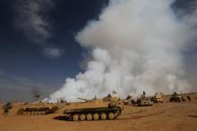 Iraqi army gather after the liberation of a village from Islamic State militants, south of Mosul, during an operation to attack Islamic State militants in Mosul, Iraq, October 21, 2016, as toxic smoke is seen over the area after Islamic State militants set fire to a sulphur factory. PHOTO BY REUTERS/Thaier Al-Sudan