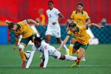 Nigeria forward Asisat Oshoala (8) falls while being defended by Australia defender Steph Catley (7) and midfielder Katrina Gorry (19) in a Group D soccer match in the 2015 FIFA women's World Cup at Winnipeg Stadium, Winnipeg, Manitoba, CAN, June 12, 2015. PHOTO BY USA TODAY Sports/Michael Chow