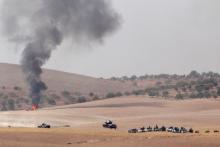 Turkish army tanks and Turkish-backed Syrian fighters make their way in the Syrian border town of Jarablus as it is pictured from the Turkish town of Karkamis, in the southeastern Gaziantep province, Turkey, August 24, 2016. PHOTO BY REUTERS/Stringer