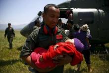 A Nepalese army personnel holds the baby of an earthquake victim after being airlifted from Sindhupalchok District to Kathmandu, Nepal May 3, 2015. PHOTO BY REUTERS/Navesh Chitrakar