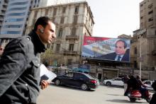 People walk by a poster of Egypt's President Abdel Fattah al-Sisi from the campaign titled “Alashan Tabneeha” (So You Can Build It) for the upcoming presidential election in Cairo, Egypt, January 22, 2018. PHOTO BY REUTERS/Amr Abdallah Dalsh