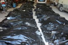Bags containing the bodies of migrants who died after their wooden boat capsized off the coast of Komas. PHOTO BY REUTERS/Ayman al-Sahili