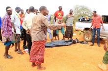 People stand near a body at the scene where a blast killed Kenyan police officers at the Garissa county, eastern Kenya, May 24, 2017. PHOTO BY REUTERS/Stringer
