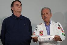 Presidential candidate Jair Bolsonaro looks on as Robson Gracie, member of the Gracie Jiu-Jitsu family, holds a knife before gifting him with a jiu-jitsu black belt at a campaign office in Rio de Janeiro, Brazil, October 25, 2018. PHOTO BY REUTERS/Ricardo Moraes
