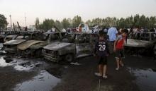 Residents gather at the site of a car bomb attack at the mainly Shi'ite district of Habibiya in Baghdad, August 15, 2015. PHOTO BY REUTERS/Wissm Al- Okili