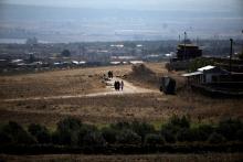People walk near the Israel-Syria border line as it is seen from the Israeli-occupied Golan Heights, Israel, July 7, 2018. PHOTO BY REUTERS/Ronen Zvulun