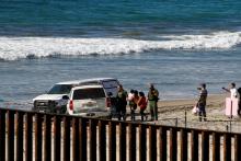 U.S. border patrol accompany Honduran migrants who turned themselves in after entering the U.S. through the border fence between Mexico and the United States, as seen from Tijuana, Mexico, November 14, 2018. PHOTO BY REUTERS/Jorge Duene