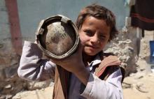 A boy holds a shell which landed from a nearby missile base after the base was struck by a Saudi-led coalition air strike, near Sanaa, April 23, 2015. PHOTO BY REUTERS/Mohamed al-Sayaghi