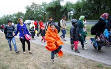A boy jumps up as he walks among other migrants towards the Austrian border in Nickelsdorf from Hegyeshalom, Hungary, September 25, 2015. PHOTO BY REUTERS/Leonhard Foeger