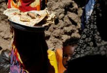 A boy looks as a woman holds bread she just made outside her hut at a makeshift camp for internally displaced people near Sanaa, Yemen, January 28, 2019. PHOTO BY REUTERS/Khaled Abdullah