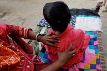 A boy with HIV-positive and under treatment, gets a back massage from his grandmother outside his family home in Ratodero, Pakistan, May 24, 2019. PHOTO BY REUTERS/Akhtar Soomro