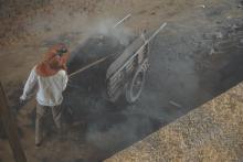 A boy shovels smoldering ash out of a kiln at a brick factory in Kandal Province, Cambodia, on January 23, 2020. PHOTO BY Thomson Reuters Foundation/Matt Blomberg