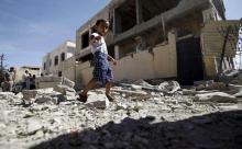 A boy walks past the a house damaged by a Saudi-led air strike in Yemen's capital Sanaa, September 12, 2015. PHOTO BY REUTERS/Mohamed al-Sayaghi