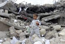 A boy walks as he collects toys from the rubble of a house destroyed by a recent air strike in Yemen's northwestern city of Saada, May 27, 2015. PHOTO BY REUTERS/Stringer