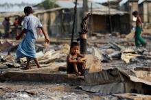 A boy sit in a burnt area after fire destroyed shelters at a camp for internally displaced Rohingya Muslims in the western Rakhine State near Sittwe, Myanmar May 3, 2016. PHOTO BY REUTERS/Soe Zeya Tun