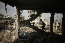 A Palestinian boy walks up the stairs inside the ruins of their house, that witnesses said was destroyed during a seven-week Israeli offensive, in the east of Gaza City, October 19, 2014. PHOTO BY REUTERS/Mohammed Salem