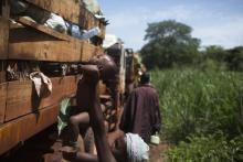 A woman passes her child on the top of a truck during a break from her journey towards Chad's border escorted by African Union operation in CAR (MISCA) a few kilometres after the northern town of Kaga Bandoro