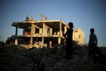 Palestinian boys play next to houses that witnesses said were destroyed during the 50-day war last summer, in the east of Gaza City, May 4, 2015. PHOTO BY REUTERS/Mohammed Salem