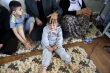 Freed Yazidi boy Murad (L), 9, who was trained by Islamic State, sits next to his five-year-old brother Emad, his parents, and his grandmother in their caravan at a refugee camp near the northern Iraqi city of Duhok, April 19, 2016. PHOTO BY REUTERS/Ahmed Jadallah