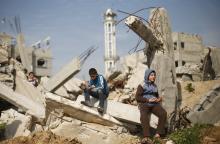 Palestinian boys attend Friday prayers as they sit at the remains of a house that witnesses said was destroyed by Israeli shelling during a 50-day war last summer, in the Shejaia neighbourhood east of Gaza City, January 23, 2015. PHOTO BY REUTERS/Suhaib Salem