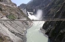 Labourers walk on a bridge near the newly inaugurated 450-megawatt hydropower project located at Baglihar Dam on the Chenab river which flows from Indian Kashmir into Pakistan, at Chanderkote, about 145 km (90 miles) north of Jammu, October 10, 2008. PHOTO BY REUTERS/Amit Gupta