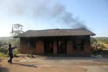 A man uses a cellphone to take pictures of a burning school office in Mashau Dolly village, in South Africa's Limpopo province, May 5, 2016. PHOTO BY REUTERS/Siphiwe Sibeko
