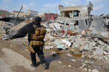 A member of the Counter Terrorism Service (CTS) walks at the site after an air strike attack against Islamic State triggered a massive explosion in Mosul, Iraq, March 29, 2017. PHOTO BY REUTERS/Stringer