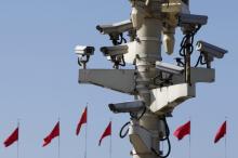 Security cameras in Tiananmen square are seen in front of flags on the Great Hall of the People where the National People's Congress (NPC) is being held, in Beijing, China, March 11, 2016. REUTERS/Kim Kyung-Hoon