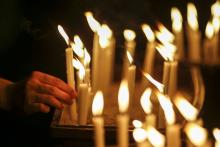A woman places a candle after a candlelight vigil for the passengers of the missing Malaysia Airlines MH370 in central Kuala Lumpur