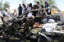 Afghan men inspect a car damaged in a suicide car bomb attack in Khost province, Afghanistan, May 27, 2017. PHOTO BY REUTERS/Stringer