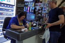 A customer waits while a cashier writes out a purchase receipt for store records, as many business have turned off their digital tills after cases of cyber attacks on business, at a store in Kiev, Ukraine, June 28, 2017. PHOTO BY REUTERS/Gleb Garanich