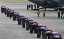 Members of the Philippine National Police's (PNP) Special Action Force (SAF) unit carry metal caskets containing the bodies of slain SAF police who were killed in Sunday's clash with Muslim rebels, upon arriving at Villamor Air Base in Pasay city, metro Manila, January 29, 2015. PHOTO BY REUTERS/Romeo Ranoco