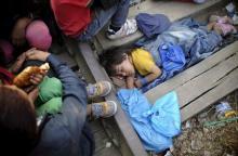 Four-year-old Rashida from Kobani, Syria, part of a new group of more than a thousand immigrants, sleeps as they wait at border line of Macedonia and Greece to enter into Macedonia near Gevgelija railway station, August 20, 2015. PHOTO BY REUTERS/Ognen Teofilovski